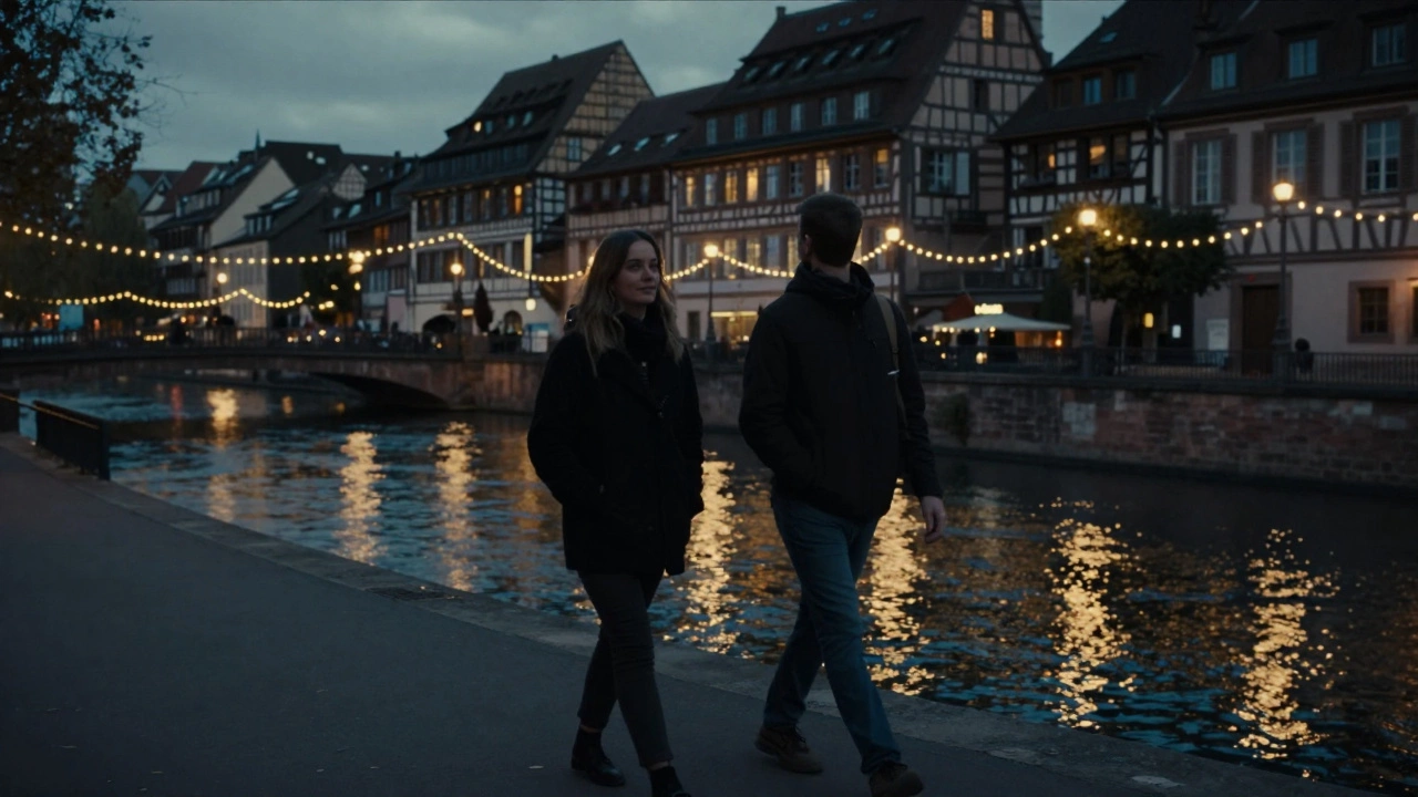 Two people walking peacefully along the Ill River in Strasbourg at dusk.